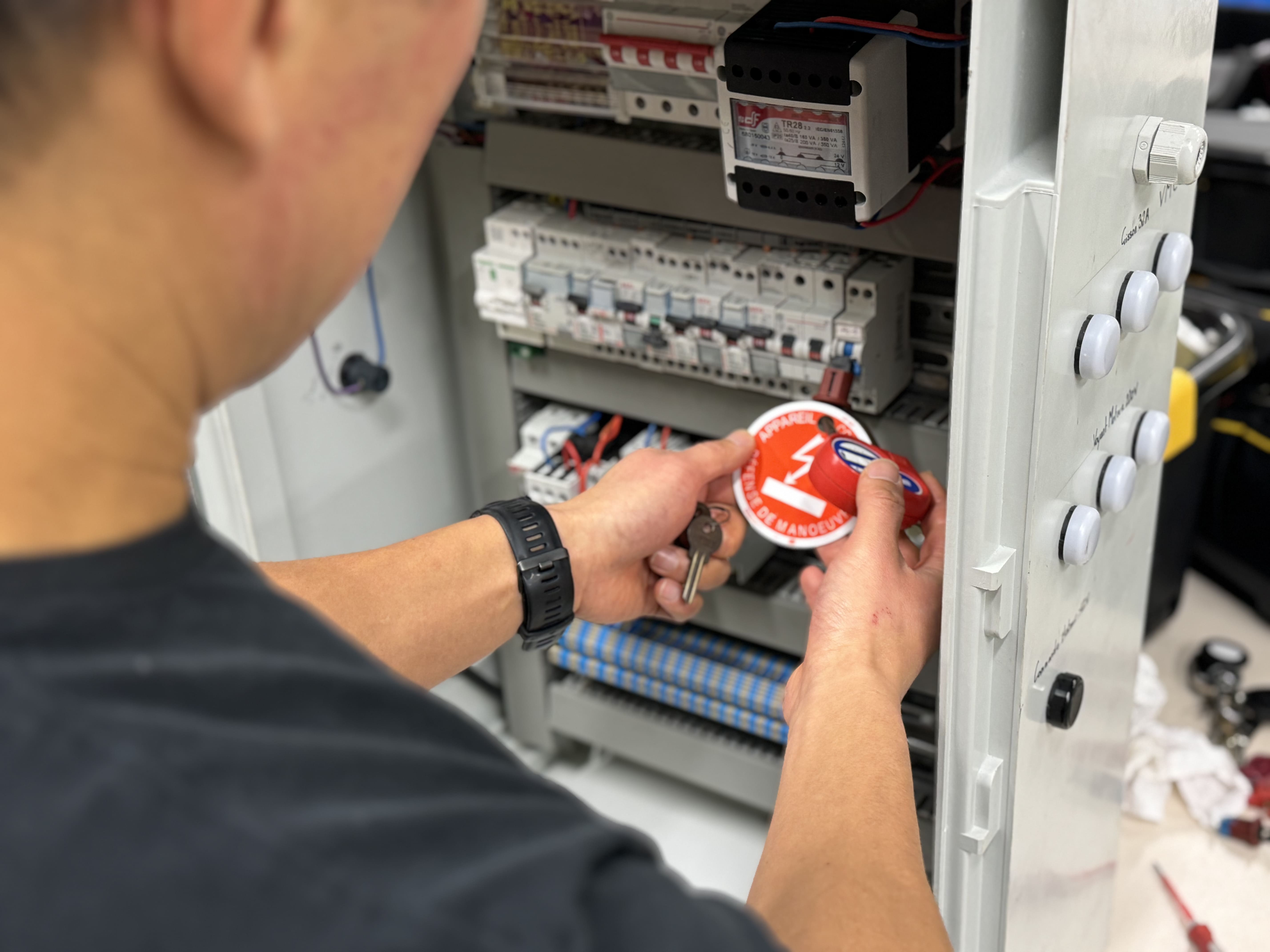 autocollant-panneau-electrique Technicien utilisant un autocollant sur un panneau électrique
