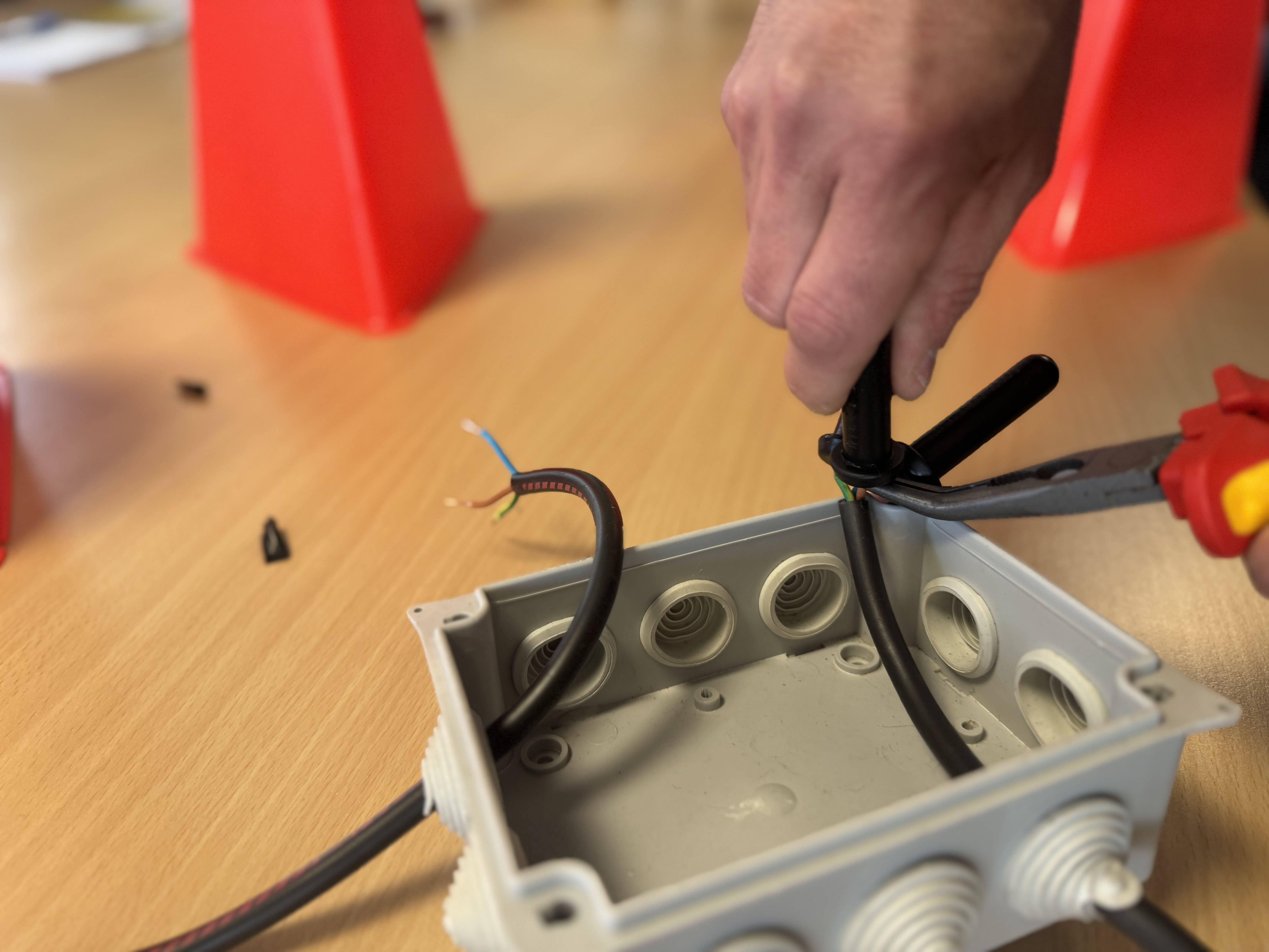 travail-boitier-electrique Personne travaillant sur un boîtier électrique